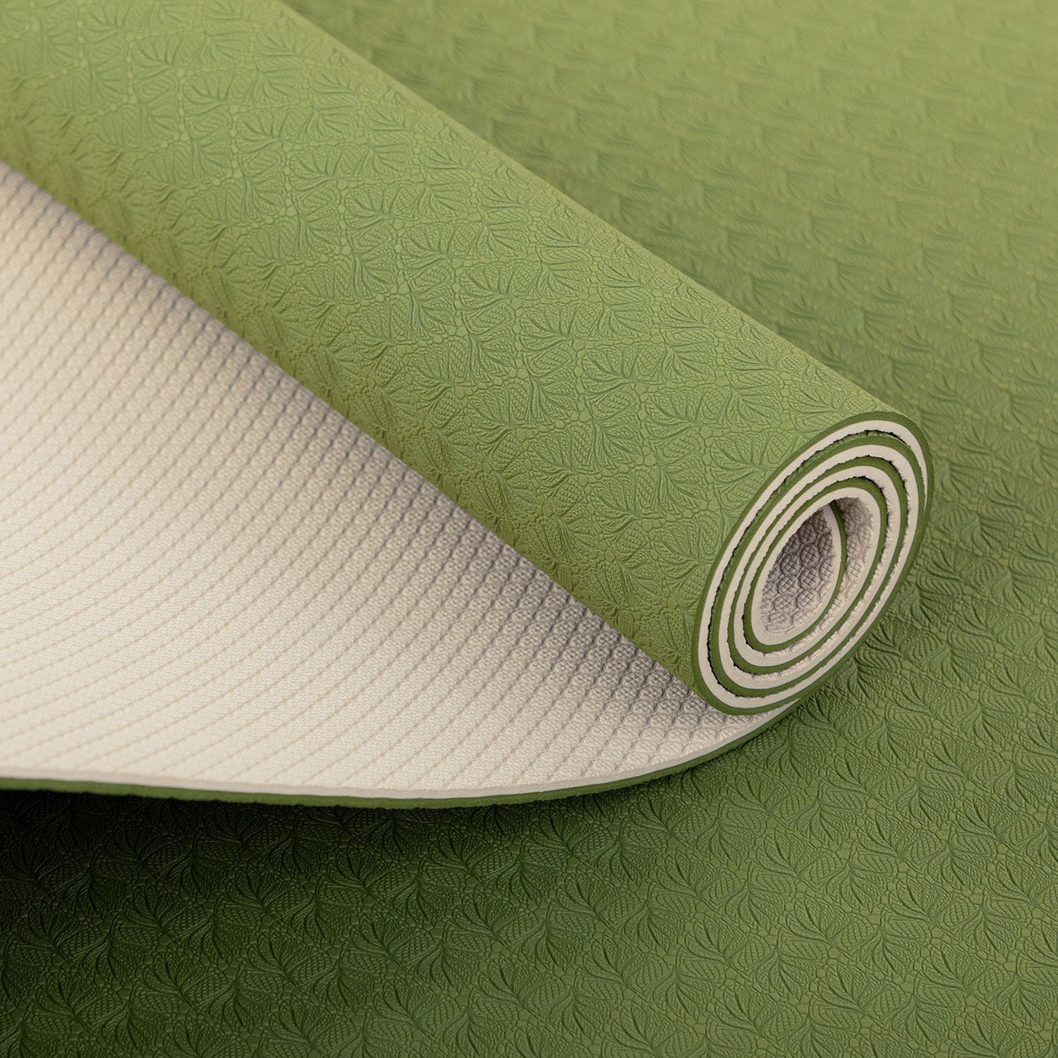 Aufgerollte Yogamatte. Grüne Oberseite mit Muster, cremefarbene Unterseite. Gerollt, Detailansicht.