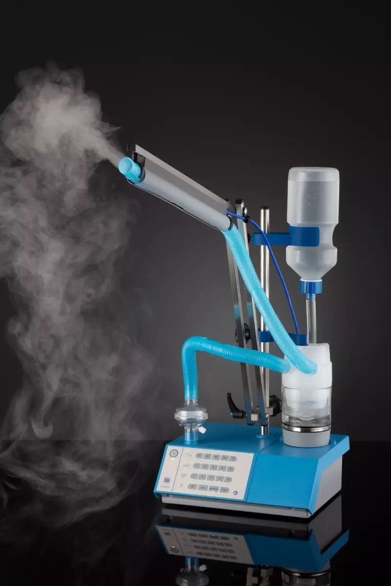 Ultraschallvernebler mit blauem Sockel, Nebelkammer, Wasserbehälter und verstellbarem Arm.