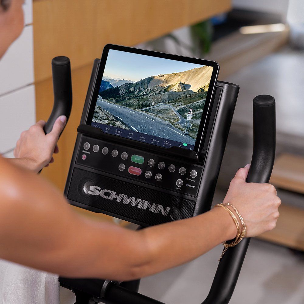 Fahrradtrainer-Konsole mit Tablet. Schwarzer Bildschirm, Landschaftsbild. Schwinn-Logo.