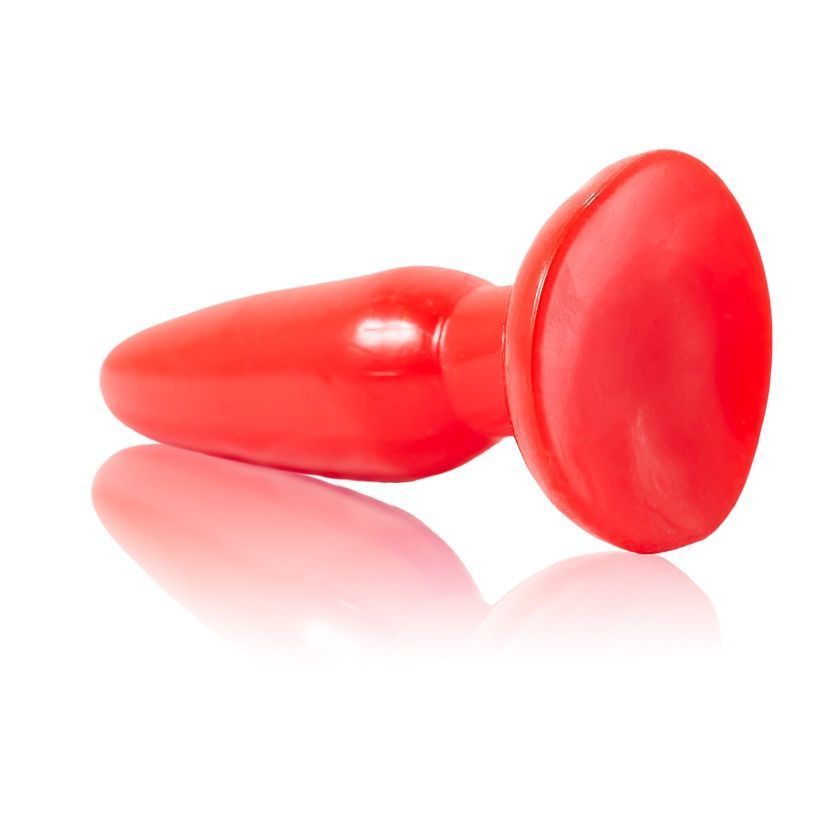 Roter Analplug, liegend. Konische Form mit breiter Basis. Reflektion auf weißem Untergrund.