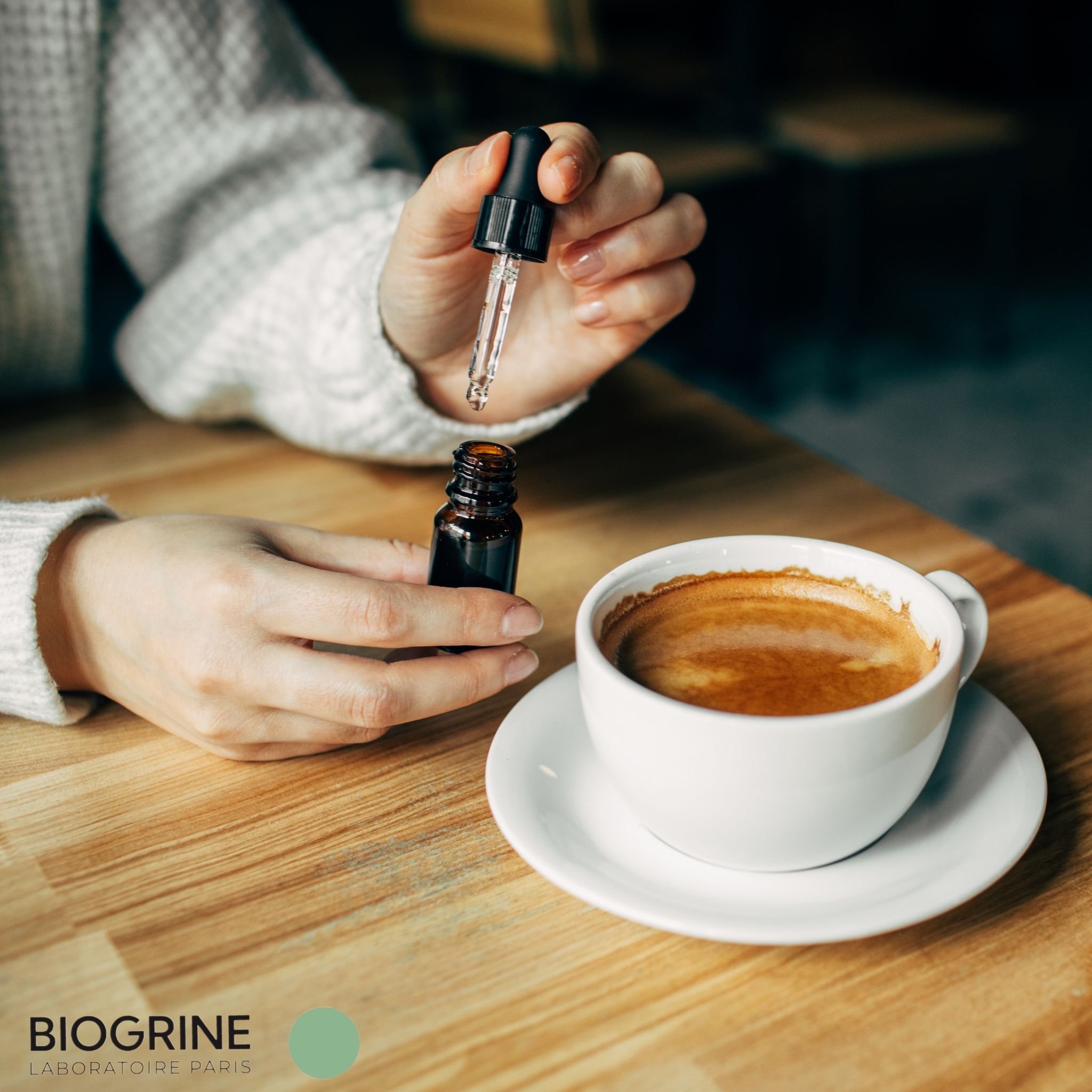 Hände halten eine braune Flasche und einen Tropfer über einer Kaffeetasse.
