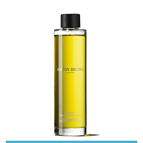Hoher Flakon mit schwarzem Deckel. Aufschrift: Molton Brown London, Coastal Cypress & Sea Fennel. Gelbe Flüssigkeit sichtbar.