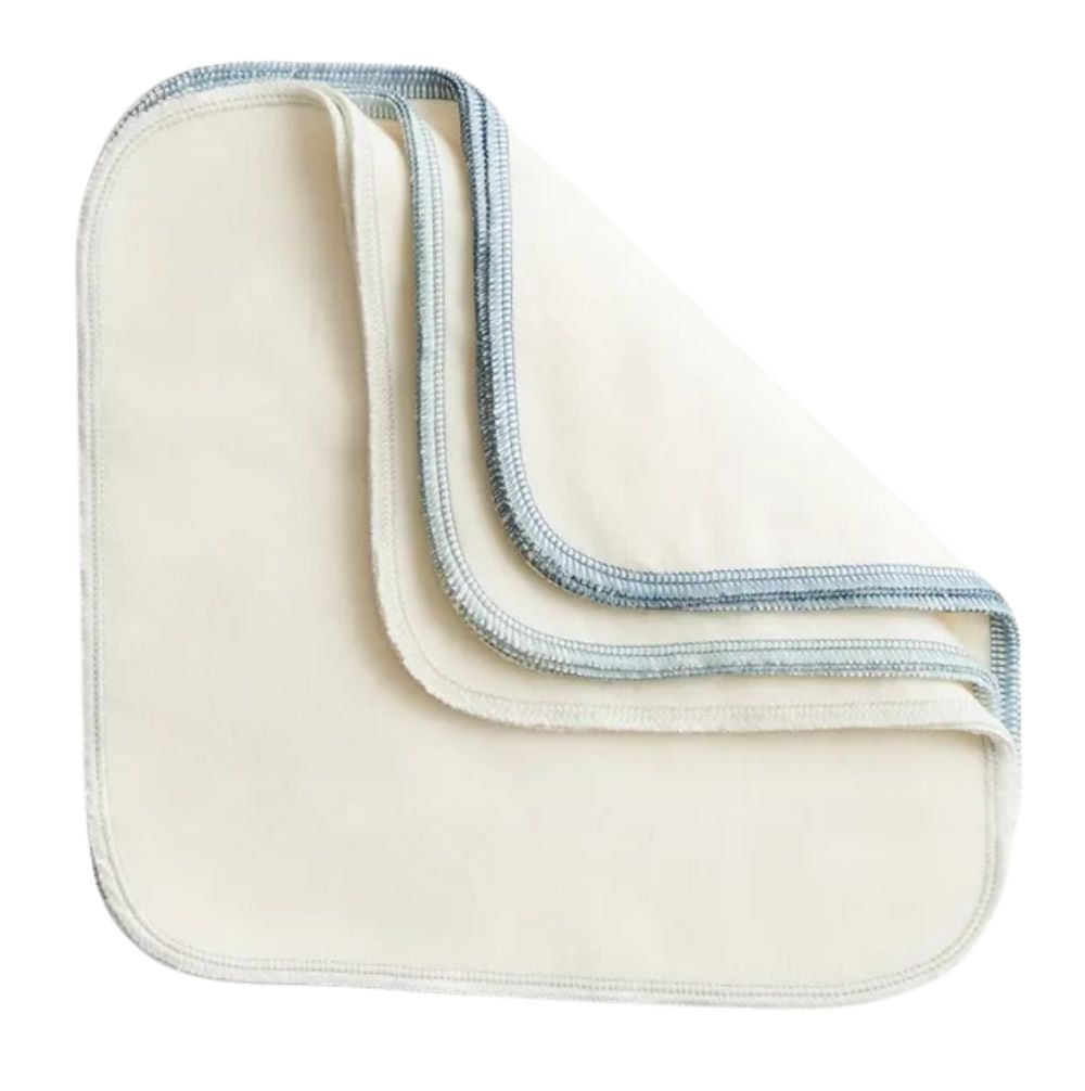 Mehrere cremefarbene Waschlappen mit blauer Naht. Abgerundete Ecken. Gestapelt, leicht gefaltet.