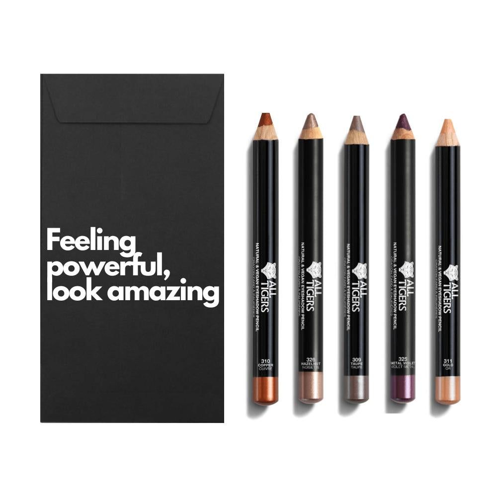 Fünf Augenstifte neben schwarzem Umschlag mit Text. Stifte in verschiedenen Farben, mit Logo und Produktbezeichnung.