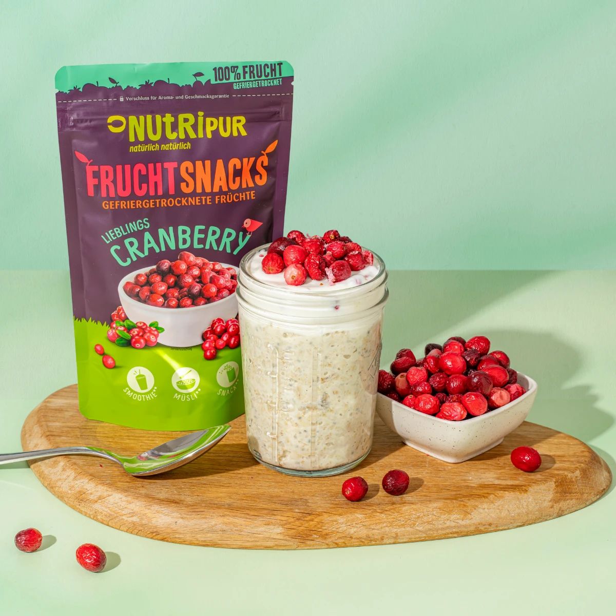 Produktverpackung, Cranberrys in Schale, und ein Glas mit Joghurt. Aufschrift: NutriPur, Frucht Snacks, Cranberry.