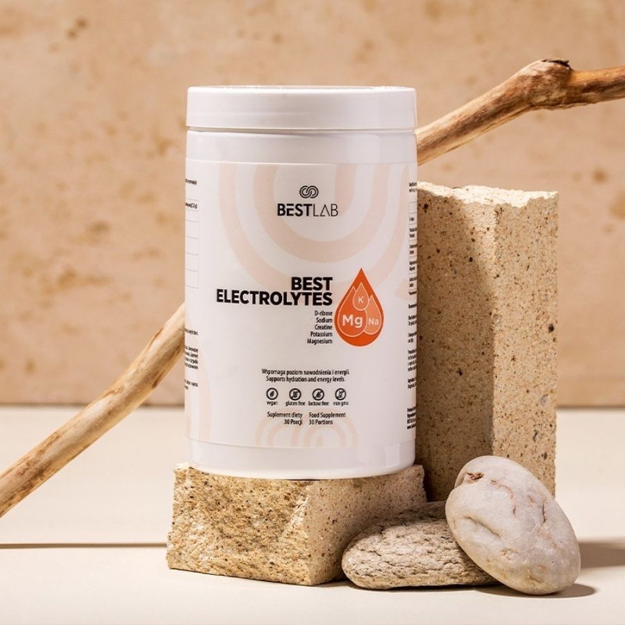 Weißer Behälter mit BEST LAB BEST ELECTROLYTES. Auf Steinen und Holz platziert. Nahrungsergänzungsmittel.