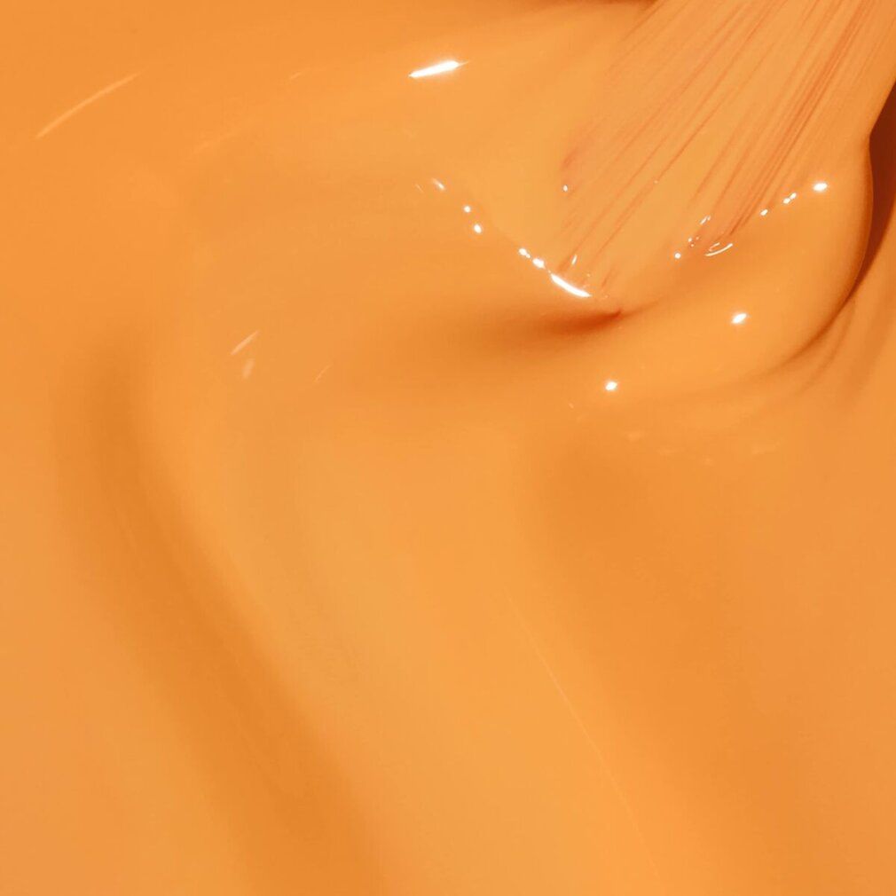 Nahaufnahme von gelb-orangem Nagellack mit Pinsel.