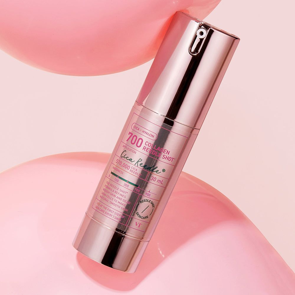 Zylindrische Flasche mit rosa Akzenten. Text: 700 Cica Reedle Shot, 20 ml. Produkt auf rosa Hintergrund. VT Cosmetics Logo.