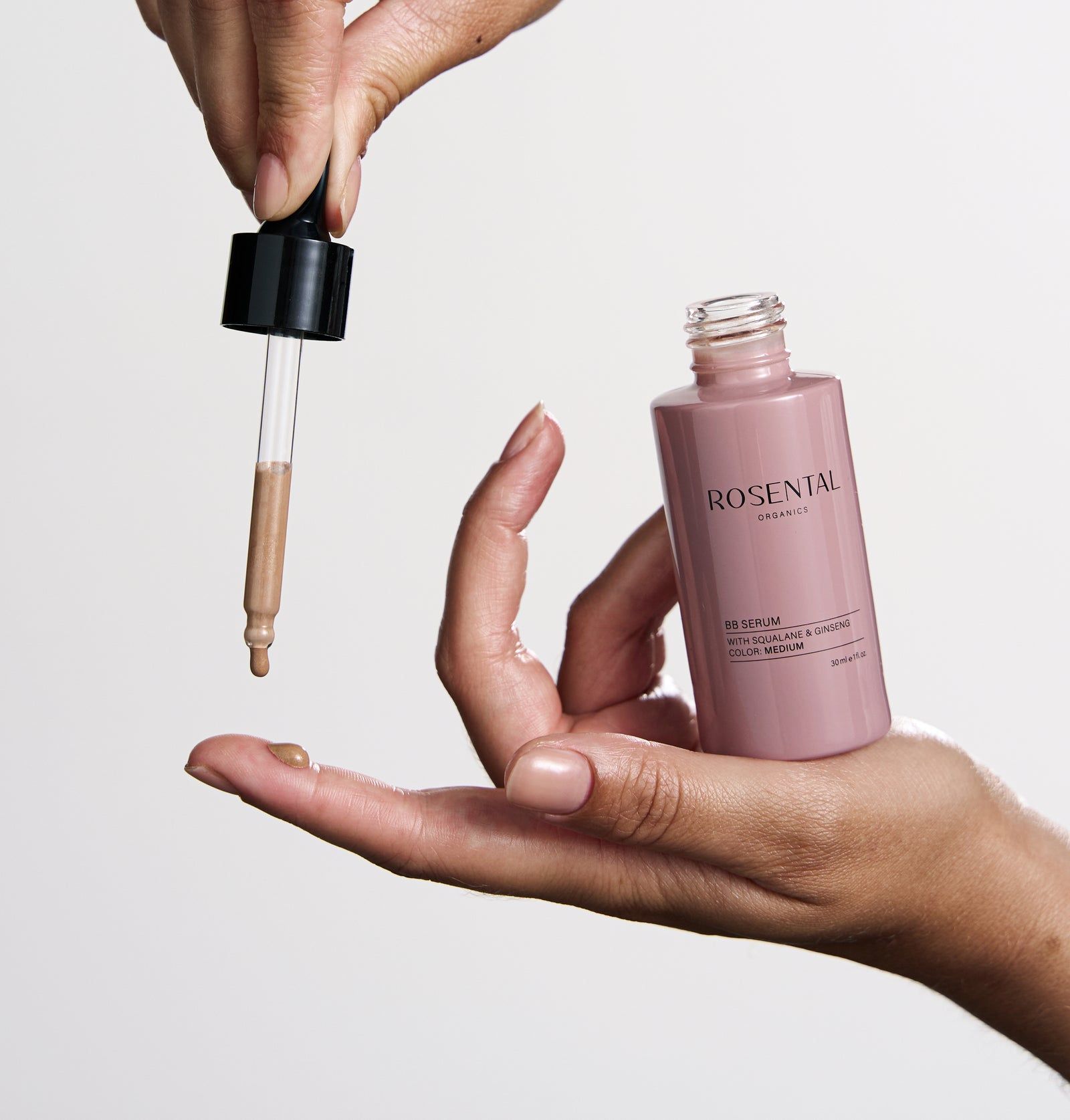 Hände halten Flasche und Pipette mit BB Serum. Produkt wird auf die Hand getropft.