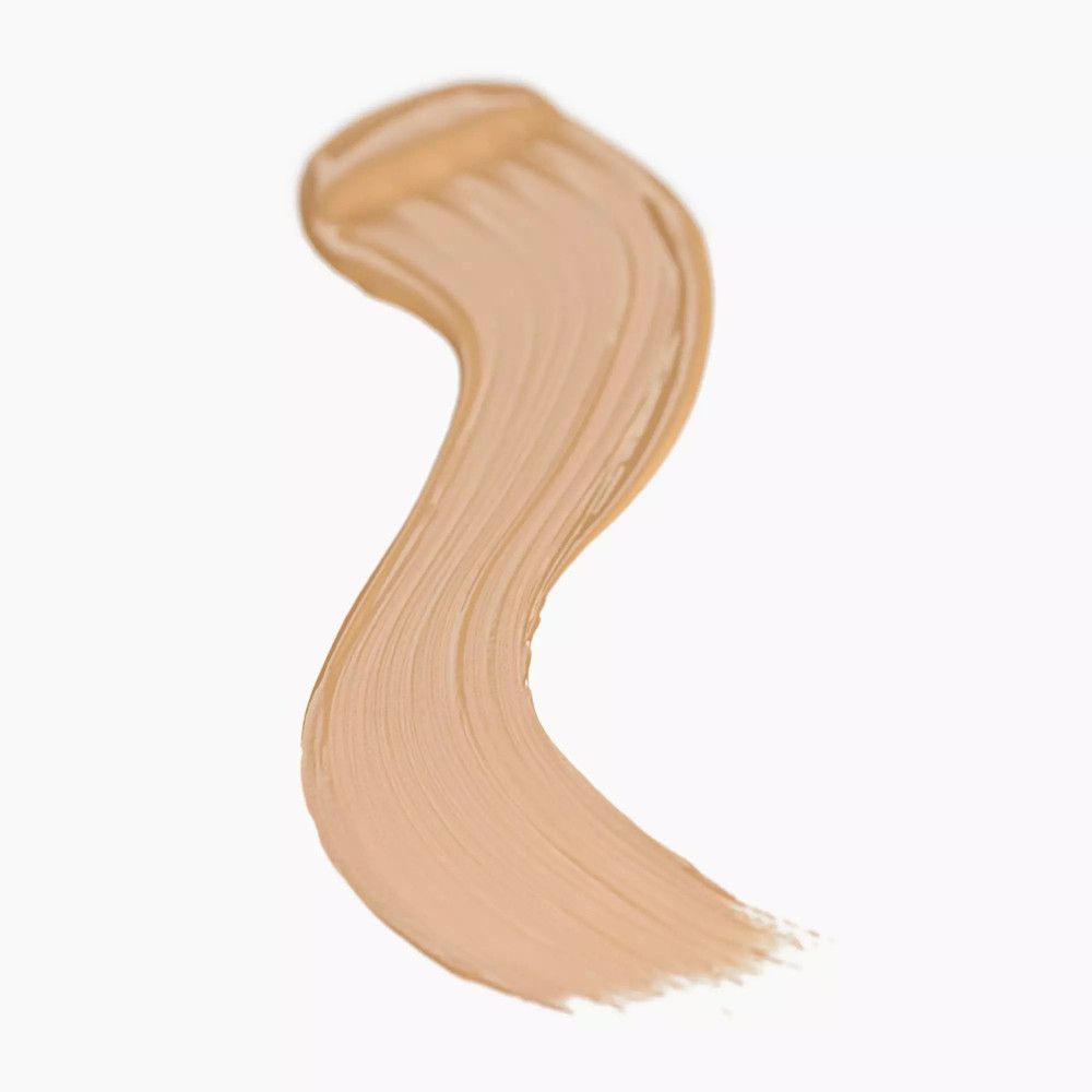 Ein geschwungener Strich Concealer in hellem Beige auf weißem Hintergrund.