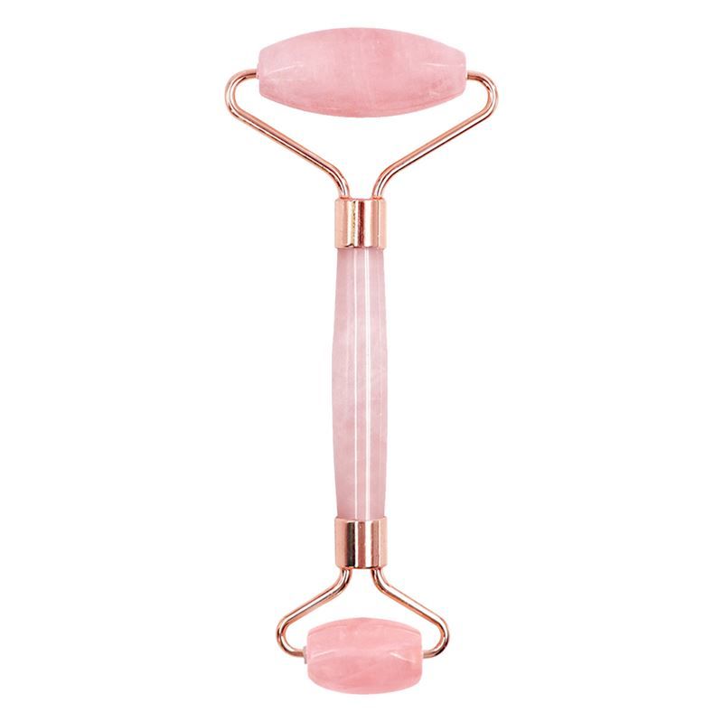 Gesichtsroller aus rosa Jade mit goldfarbenen Metallrahmen. Der Roller hat zwei Rollköpfe und einen Griff.