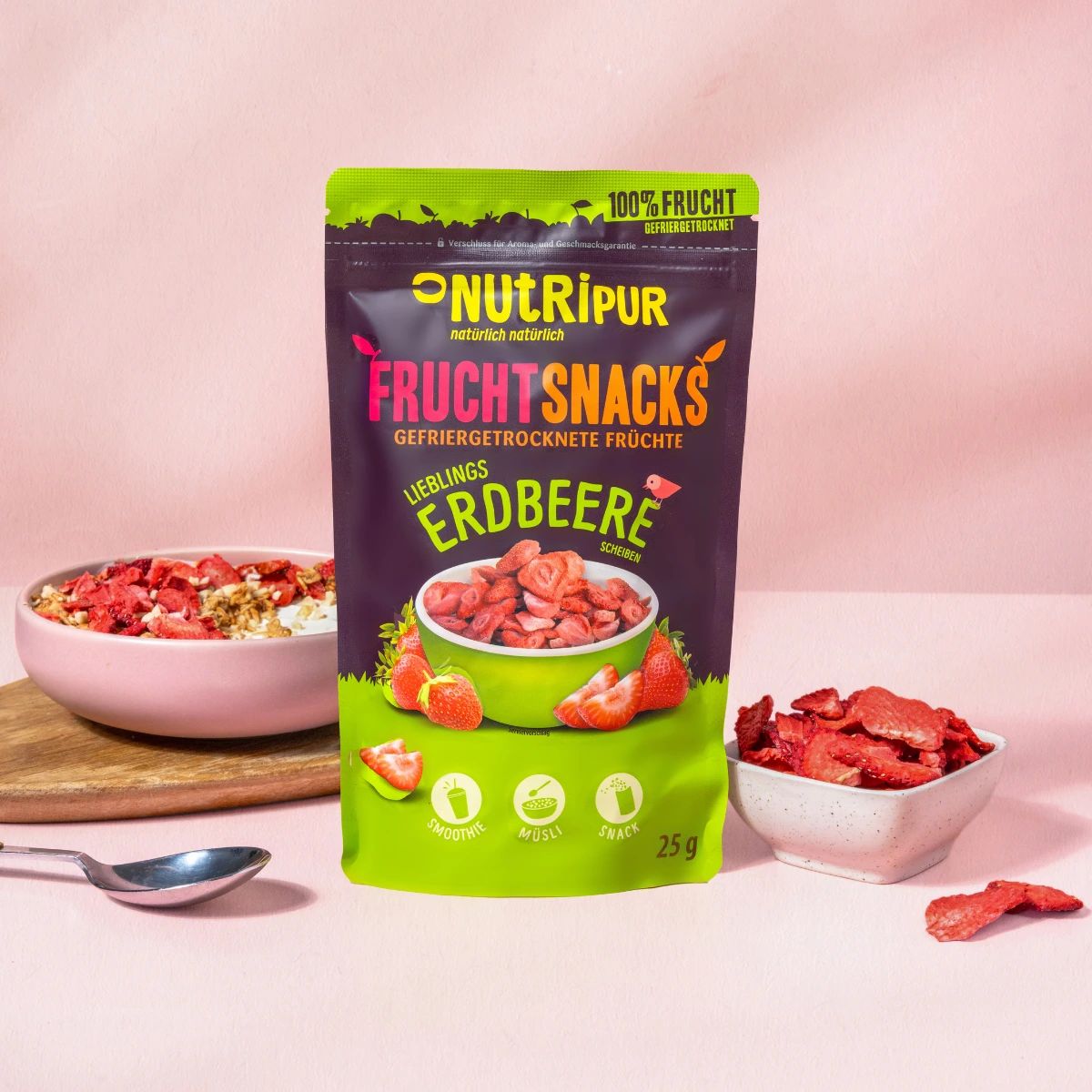 Beutel mit gefriergetrockneten Erdbeeren und eine Schüssel mit Erdbeeren und Müsli. Aufschrift: NutriPur Fruchtsnacks Erdbeere.