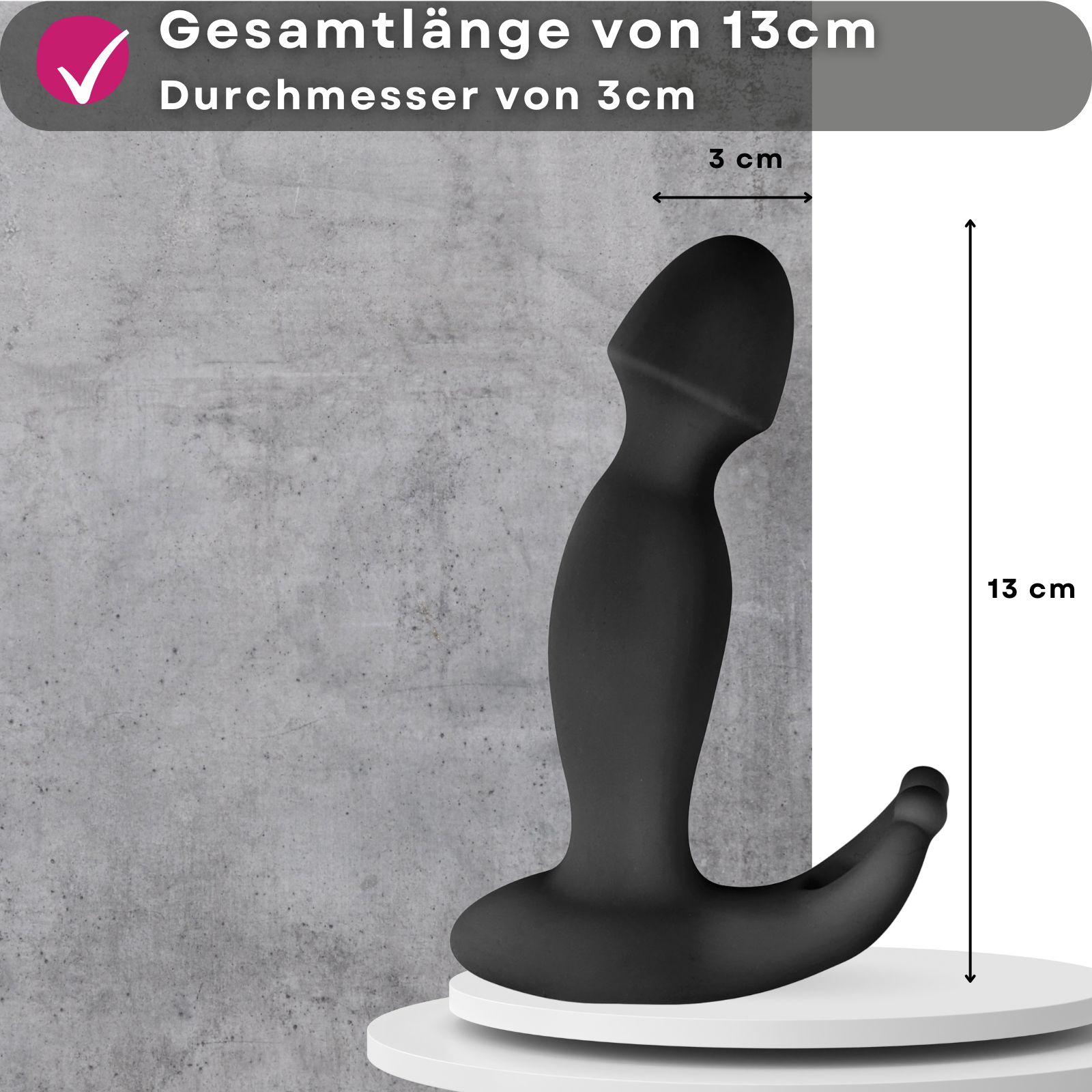 Schwarzer Vibrator. Text: 13 cm Gesamtlänge, 3 cm Durchmesser. Auf Podest.