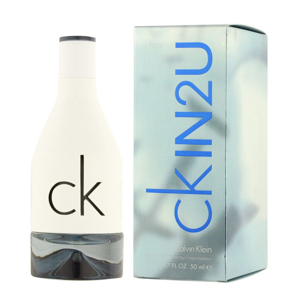 Weißes Parfümflakon und Schachtel. Aufschrift: ck IN2U, Calvin Klein. Flakon mit silberfarbenem Boden und schwarzem Deckel.