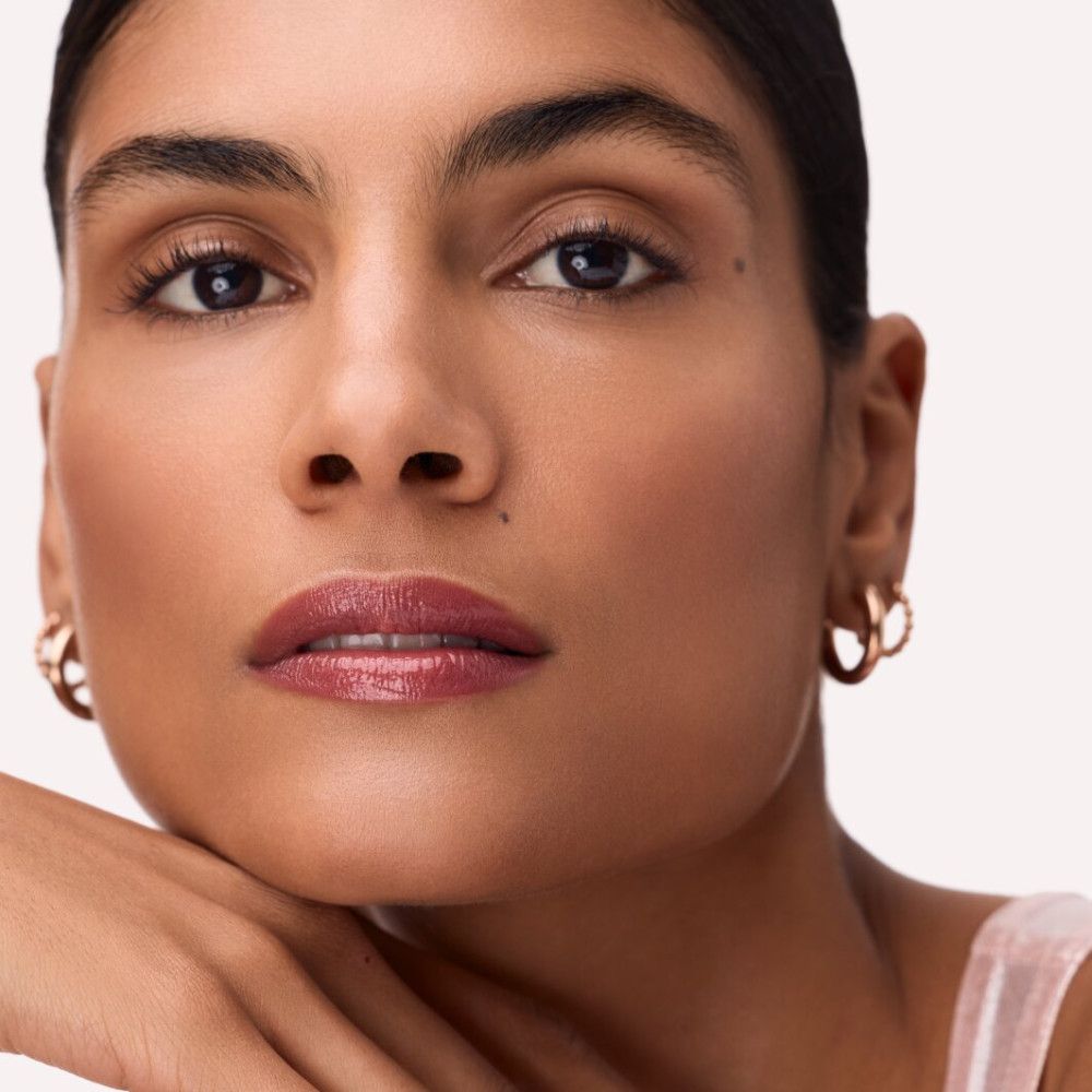 Porträt einer Frau mit Catrice Colour Glaze Lip Tint. Die Lippen sind in einem rosafarbenen Farbton geschminkt.