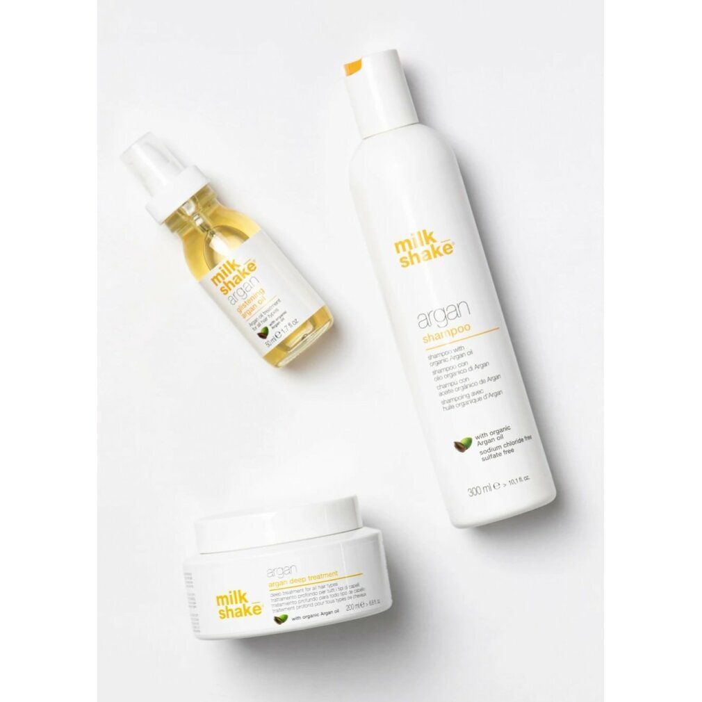 Drei Produkte: Shampoo, Öl und Creme. Aufschrift: Milk_shake argan. Mit Arganöl. Weißes Design.