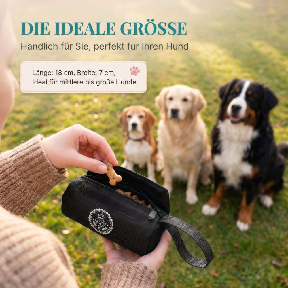 Person hält einen schwarzen Futterbeutel. Drei Hunde im Hintergrund. Text: DIE IDEALE GRÖSSE. Länge 18 cm, Breite 7 cm.