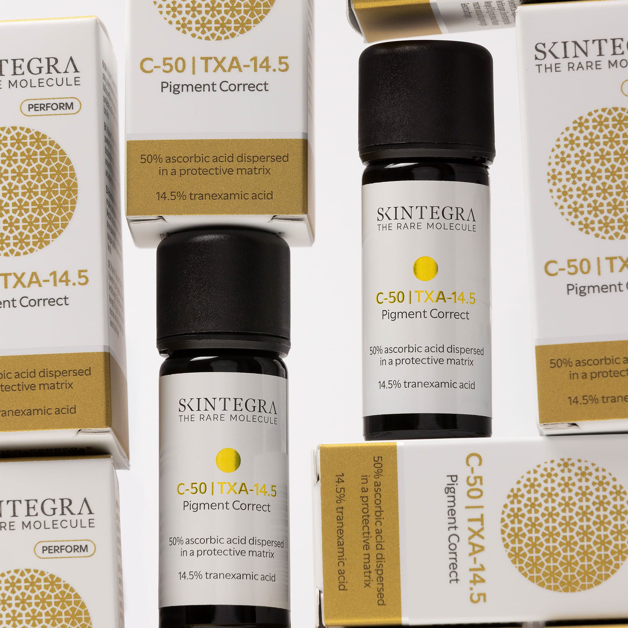 Mehrere Skారా Integra C-50 | TXA-14.5 Pigment Correct Verpackungen und Serumfläschchen.