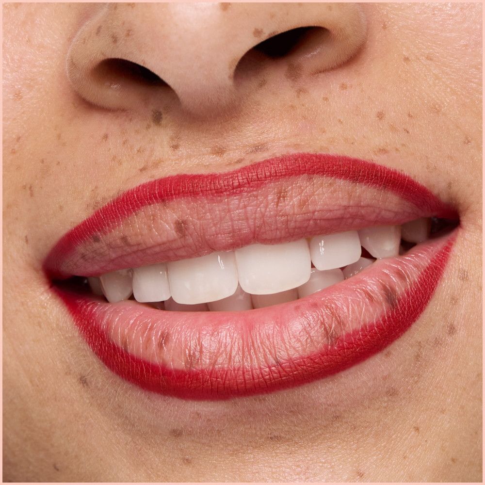Nahaufnahme von Lippen mit rotem Lippenstift. Weiße Zähne sichtbar.