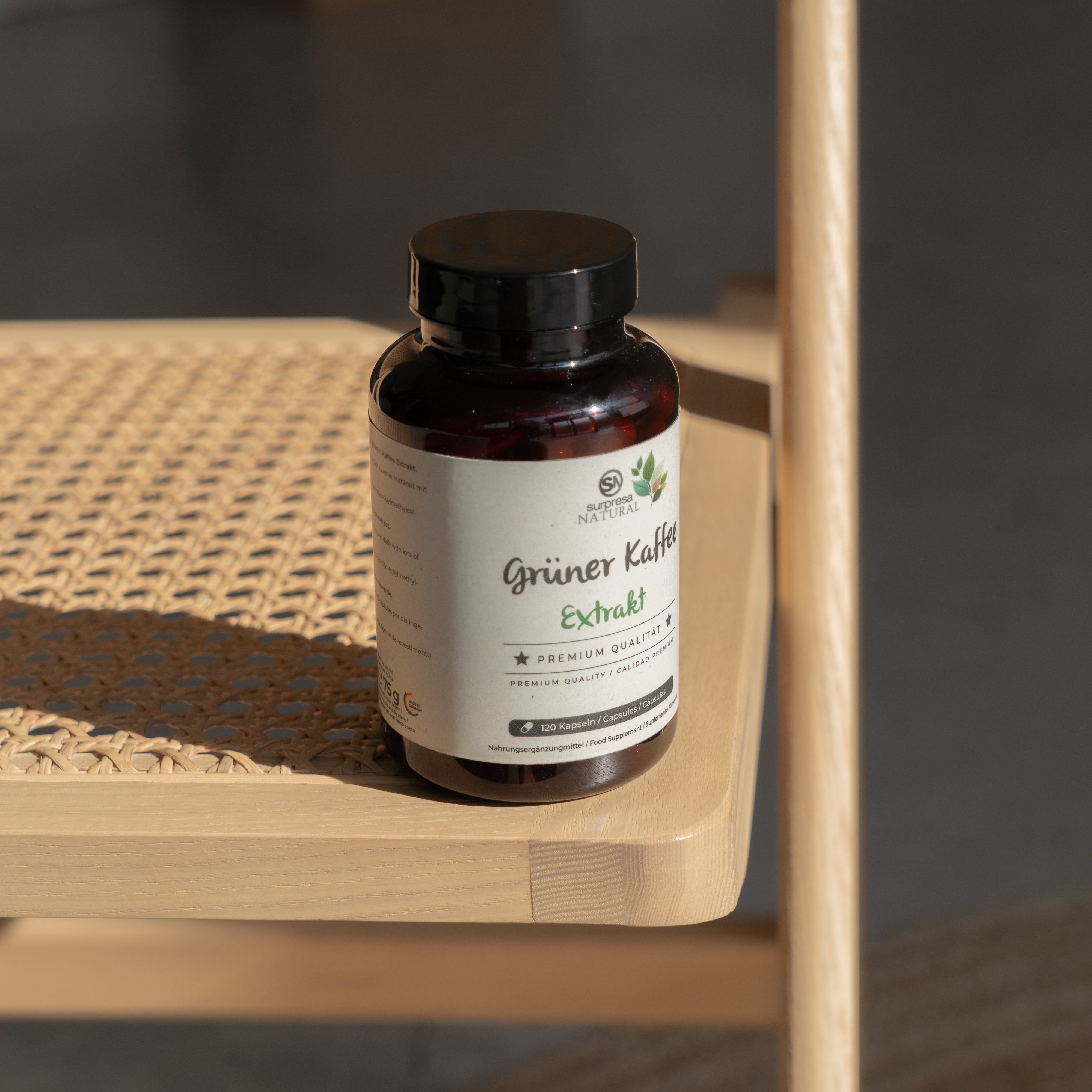 Braune Kapsel auf Holzoberfläche, Etikett: Grüner Kaffee Extrakt, 120 Kapseln.