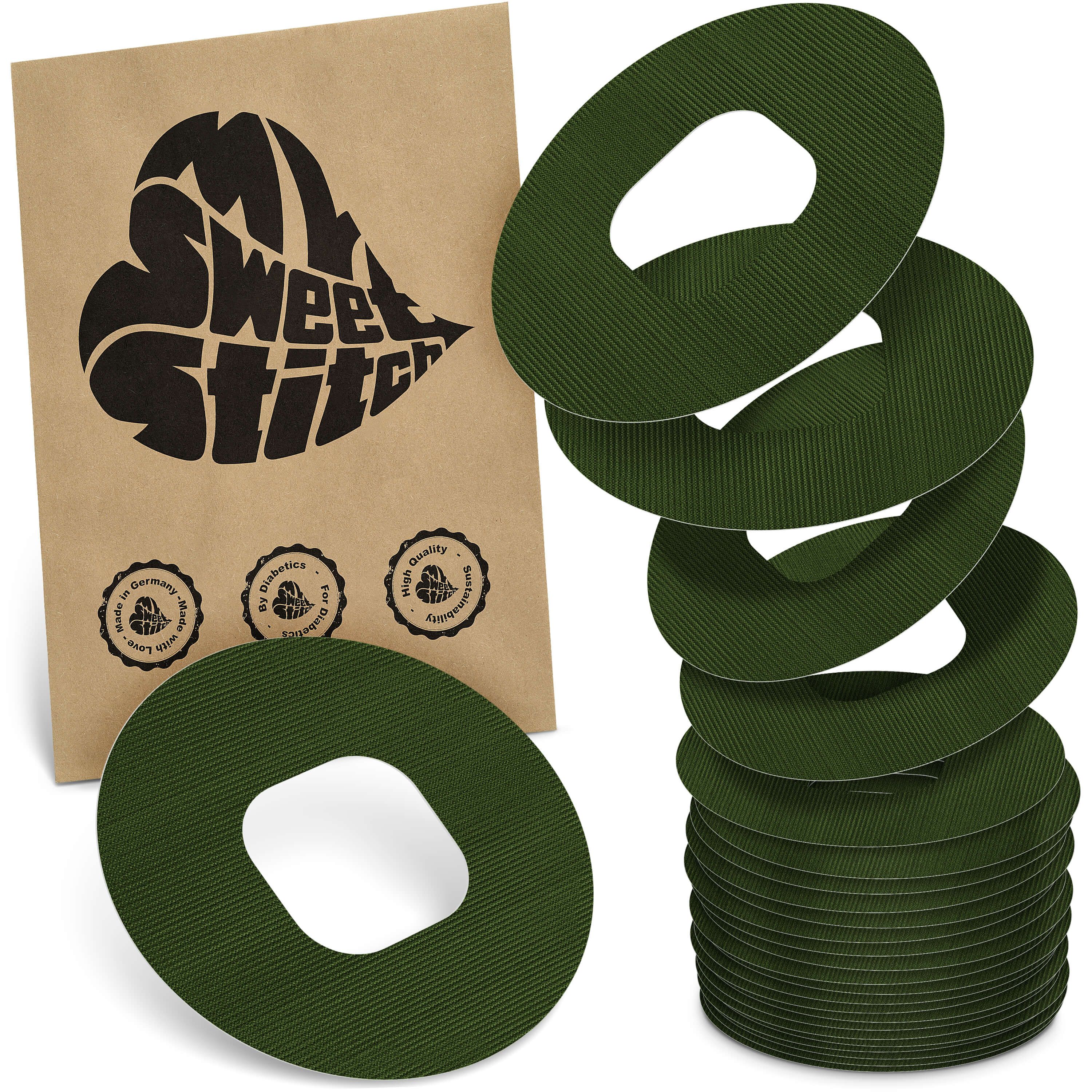 Grüne, ringförmige Pflaster mit Loch. Neben einer braunen Verpackung mit Logo und Qualitätssiegeln gestapelt.
