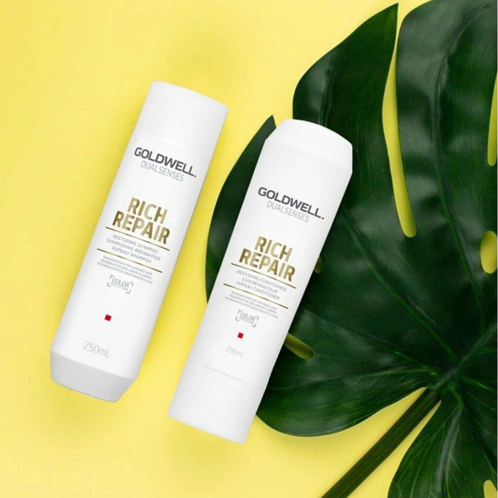 Zwei weiße Flaschen Goldwell Rich Repair Shampoo. Auf gelbem Hintergrund mit Blatt. Text: Restoring Shampoo, 250ml.