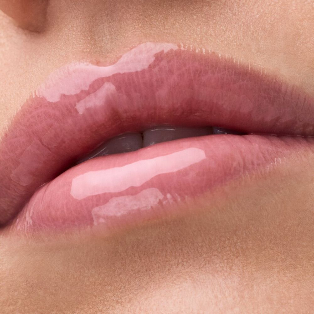 Nahaufnahme von Lippen mit glänzendem Lipgloss. Die Lippen sind rosa und glänzend.