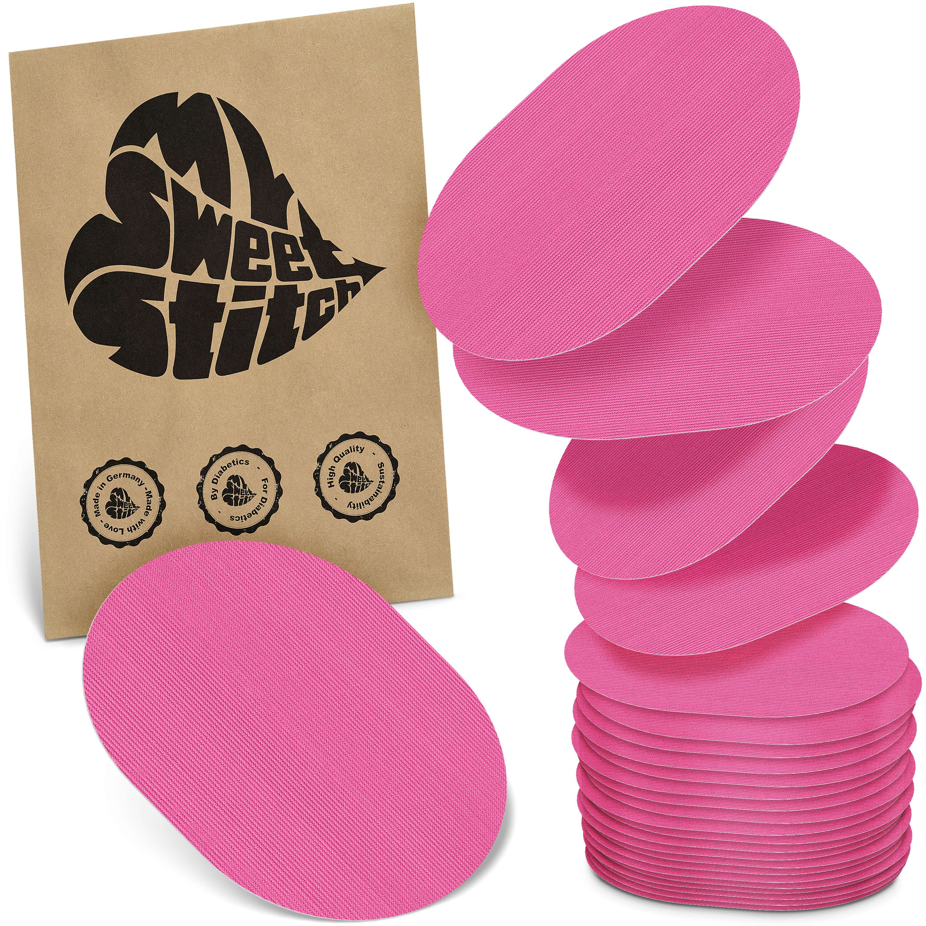 Rosa ovale Pflaster. Einige sind gestapelt, andere liegen daneben. Eine Papiertüte mit Logo und Qualitätssiegeln.