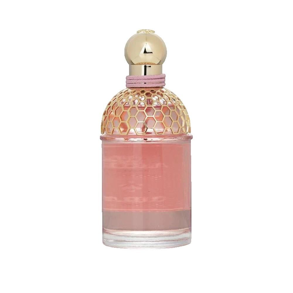 Parfümflasche mit goldfarbenem Deckel, rosa Flüssigkeit und rosa Band. Honigwabenmuster auf dem Flaschenkopf.