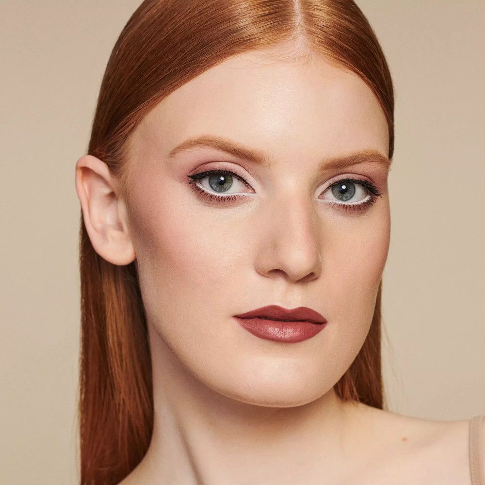 Porträt einer Frau. Lippenstift auf den Lippen. Augen mit Lidschatten und Eyeliner.