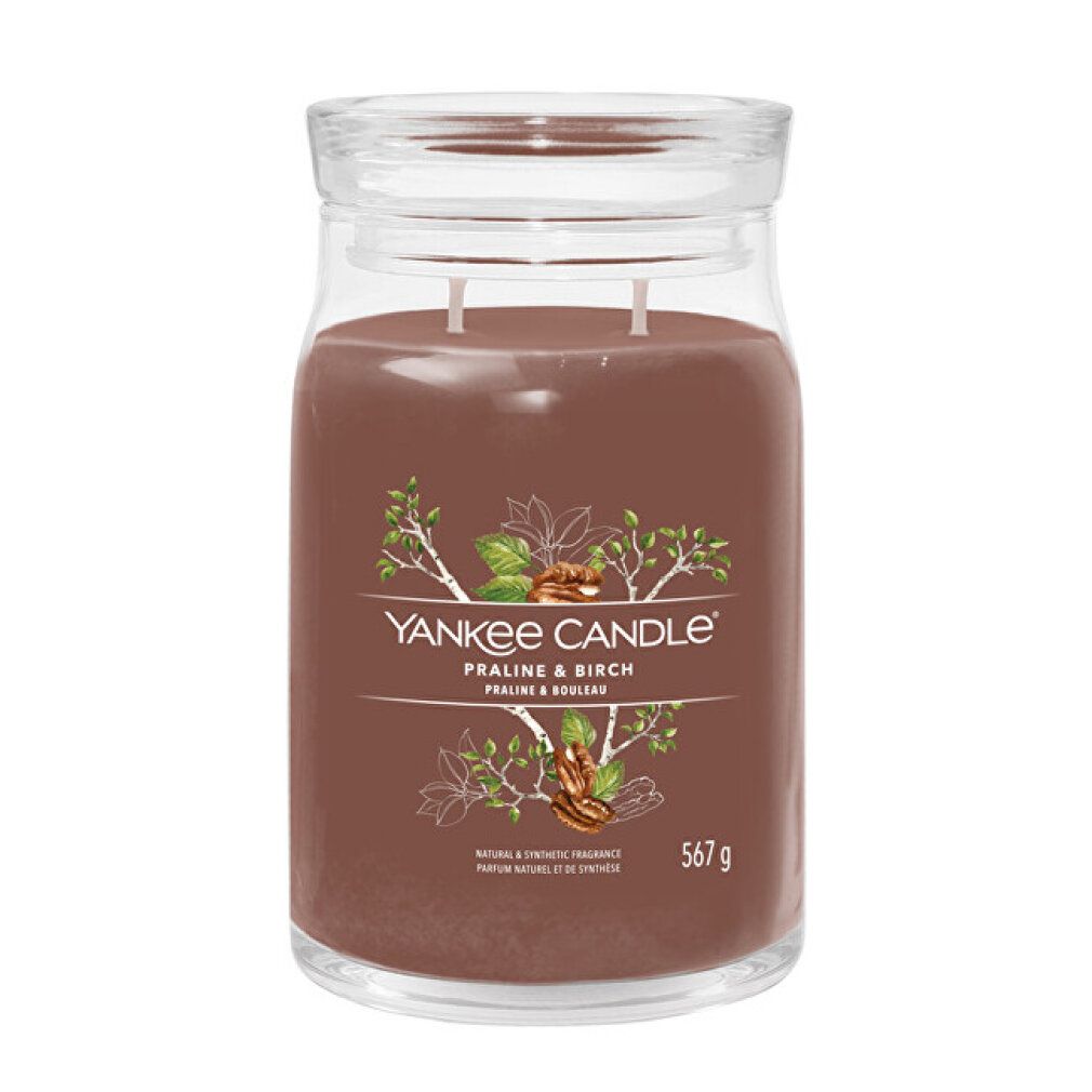 Glasbehälter mit Deckel, braunem Wachs und zwei Dochten. Etikett mit Schriftzug "Yankee Candle Praline & Birch" und 567 g.