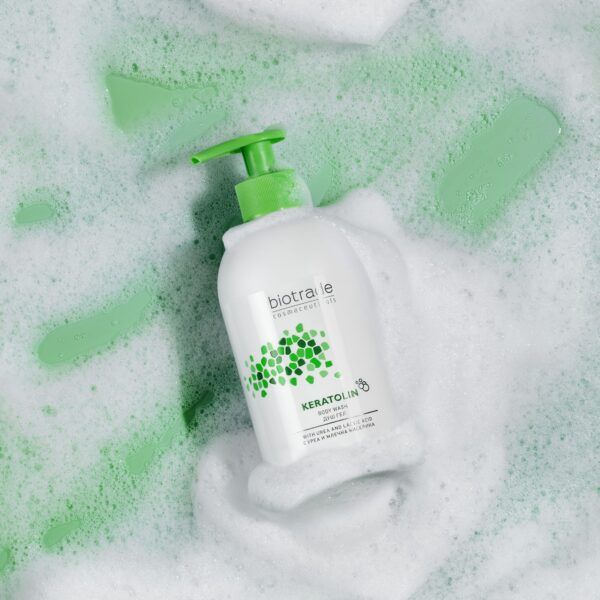 Weißer Spender mit grünem Pumpkopf in Seifenschaum. Aufschrift Biotrade Keratolin.