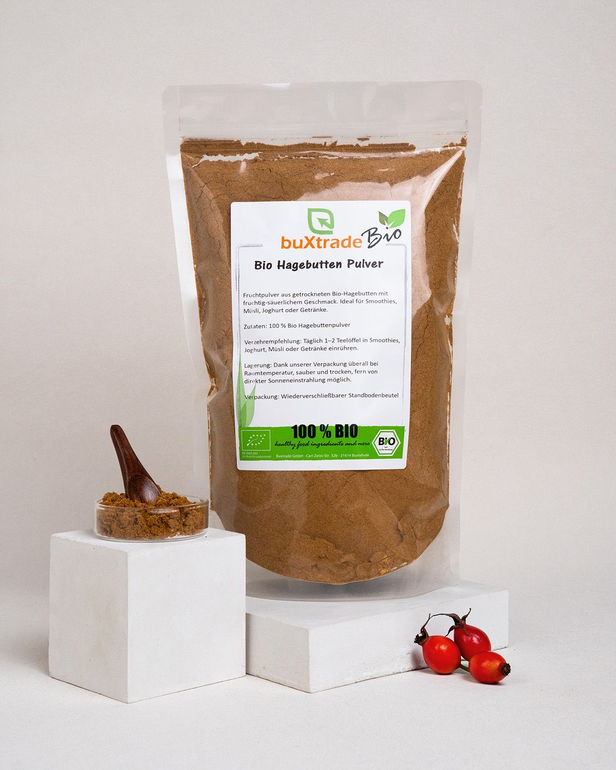 Produktpräsentation mit Beutel, Glasbehälter und Hagebutten. buXtrade Bio Hagebuttenpulver, Bio-Siegel.