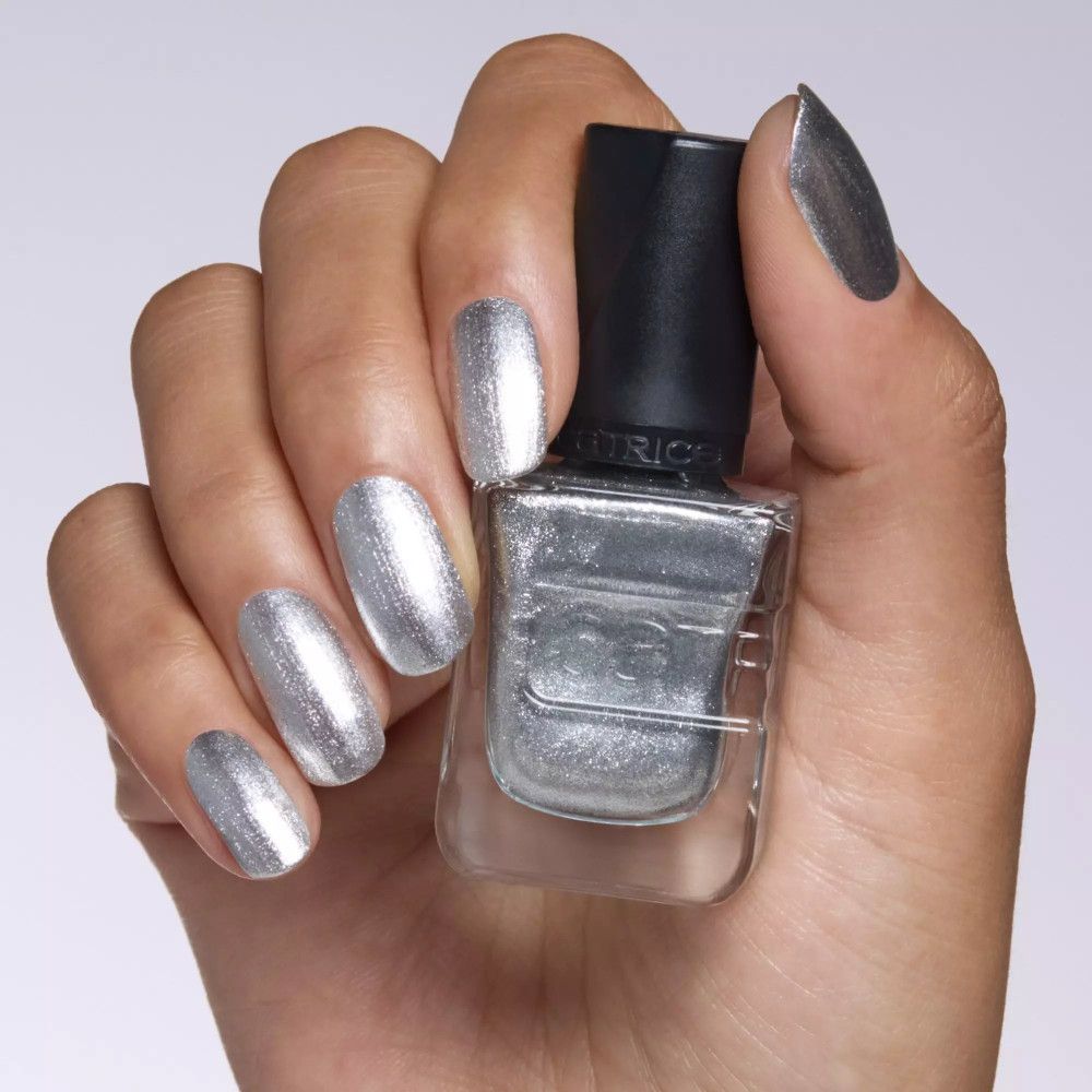Hand mit silber lackierten Nägeln, Nagellackflasche mit schwarzem Deckel. Marke Catrice.