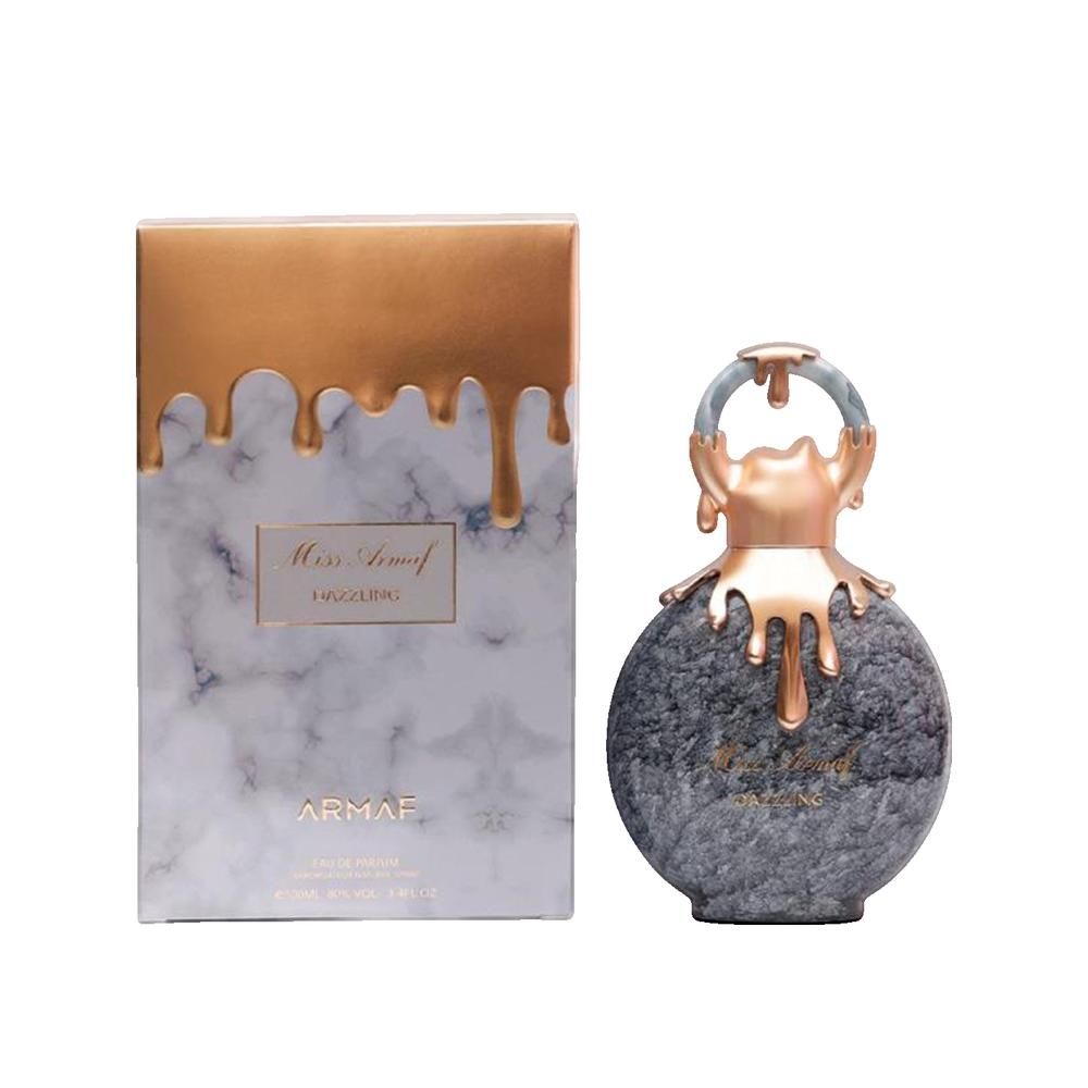 Parfümflakon und Schachtel. Flakon rund, grau marmoriert, goldfarbene Elemente. Schachtel marmoriert, goldfarbener Aufsatz. Schriftzug: Miss Armaf Dazzling.