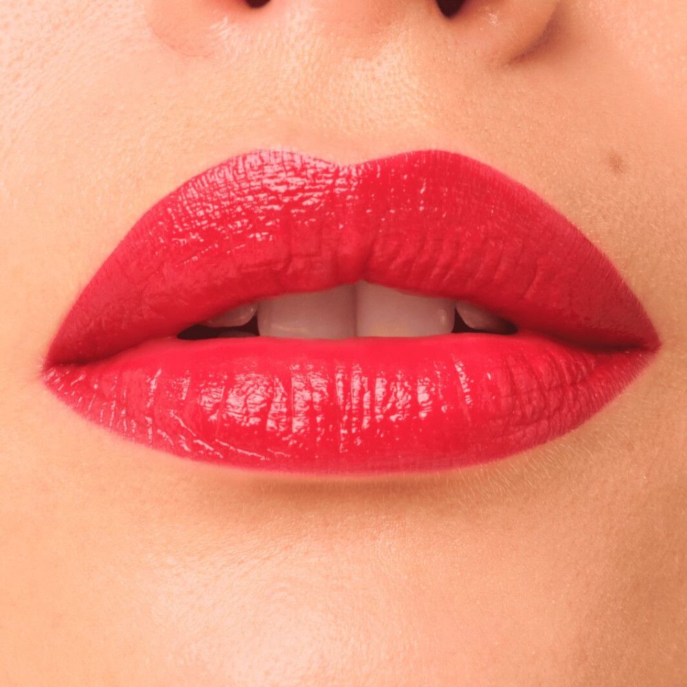 Nahaufnahme von geöffneten Lippen. Lippenstift in leuchtendem Rot. Haut um die Lippen sichtbar.