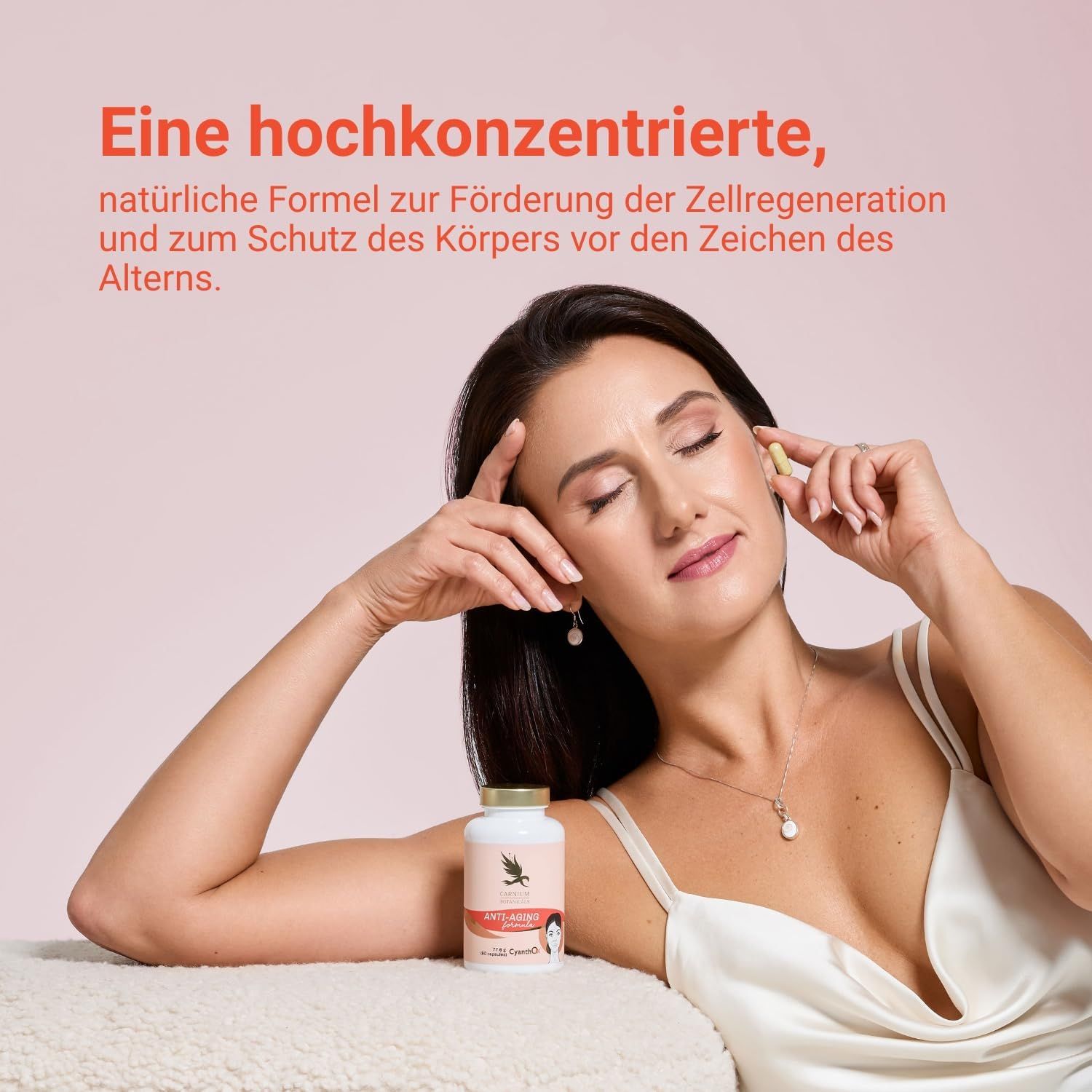 Frau hält Kapsel und Pillenfläschchen. Fläschchen mit goldenem Deckel. Aufschrift: Anti-Aging formula.
