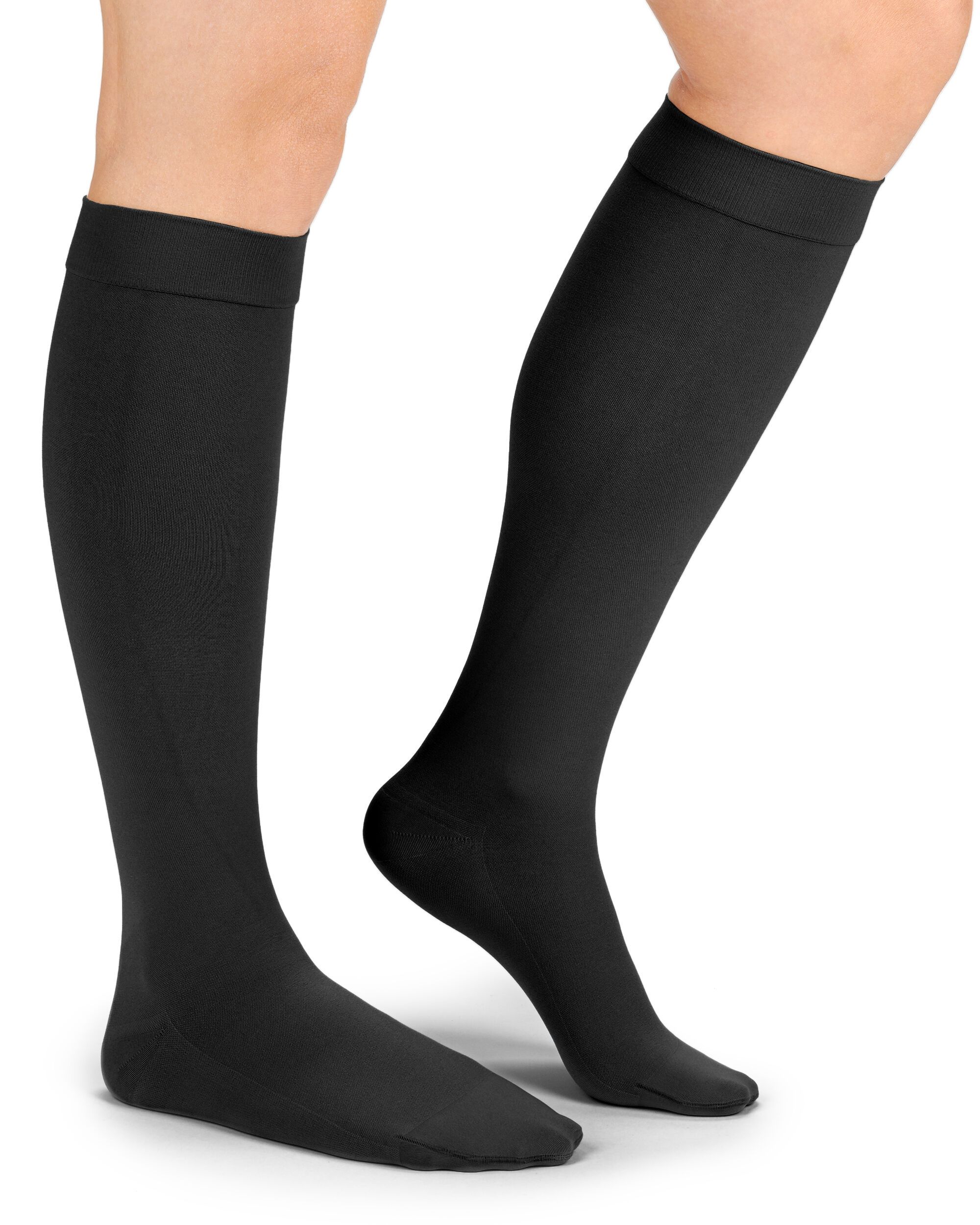 Schwarze Kompressions-Kniestrümpfe an Beinen. Blick von der Seite. Strümpfe reichen bis unterhalb des Knies.