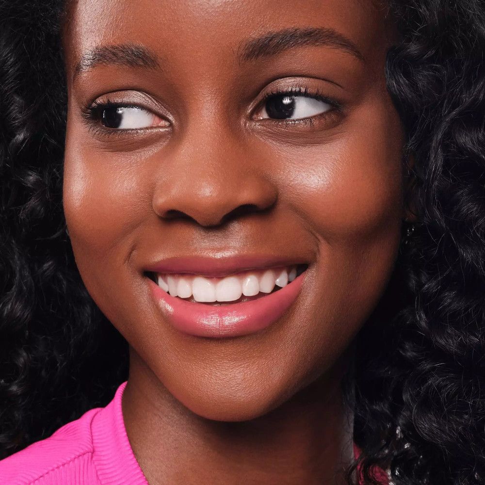 Porträt einer Frau mit rosa Lippen. Sie blickt zur Seite.