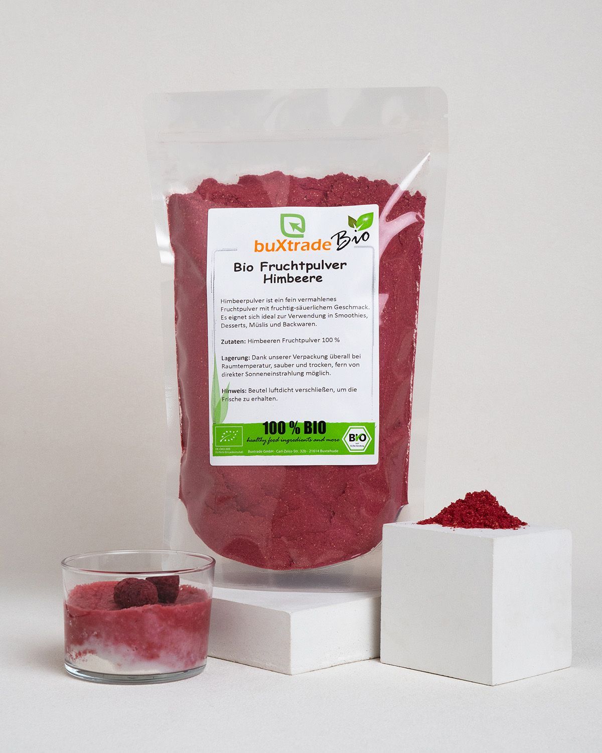 Verpackung mit Himbeerpulver, ein Glas mit Himbeerzubereitung und ein Würfel mit Pulver.