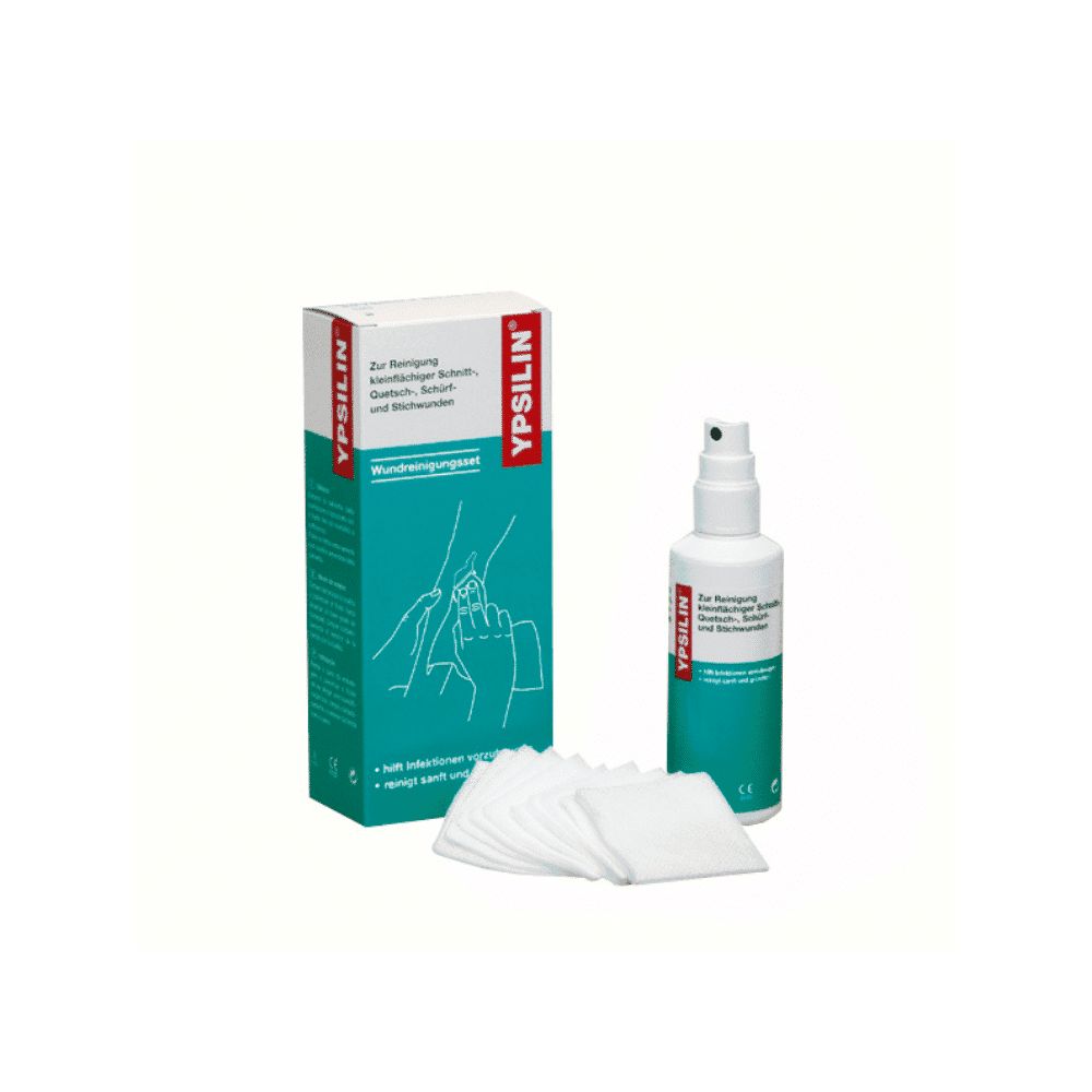 Verbandmittel-Set. Box und Flasche mit Sprühkopf. Wattepads liegen davor. Text: YPSILIN, Wundreinigungsset.