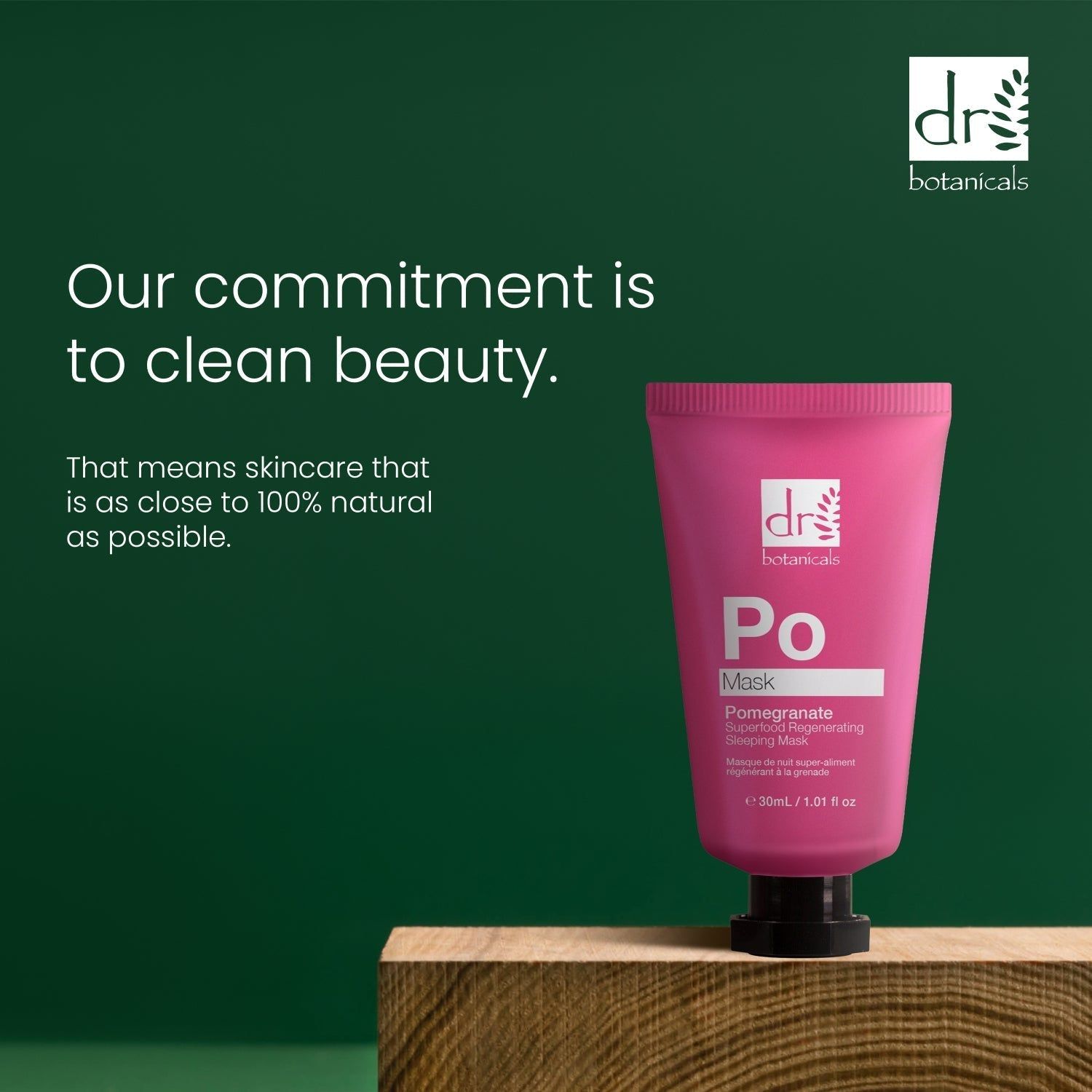 Rosa Tube auf Holzblock. Aufschrift: Dr Botanicals, Po Mask, Pomegranate Superfood Regenerating Sleeping Mask. Grüner Hintergrund.
