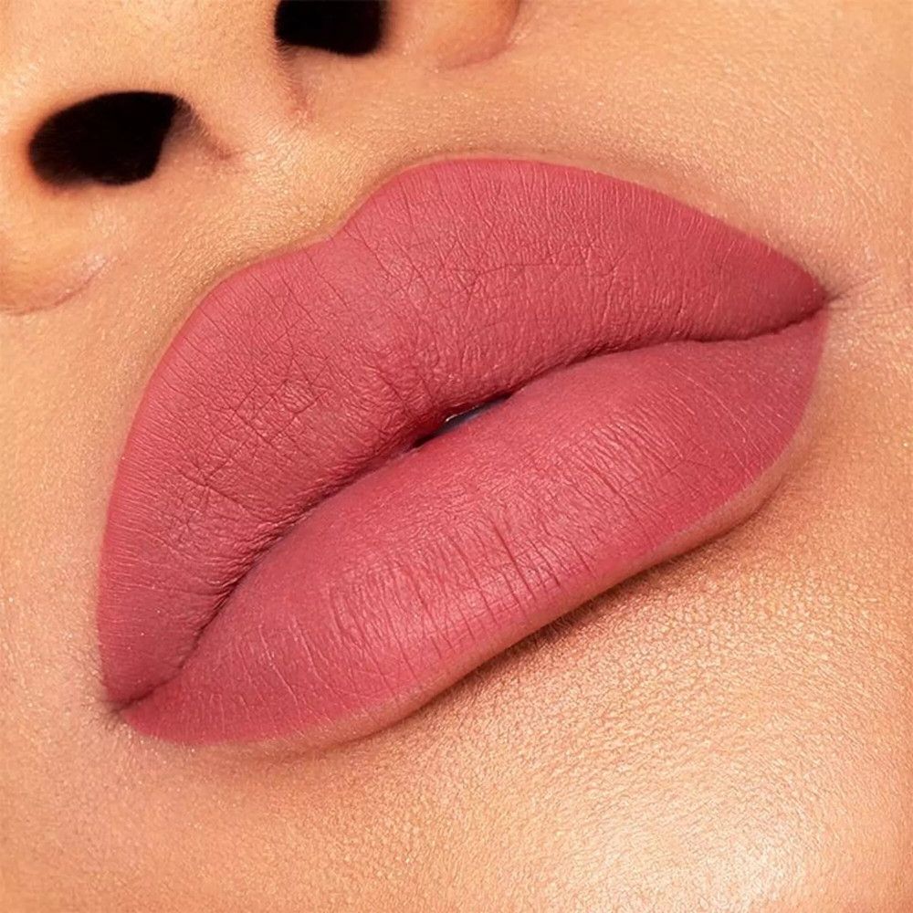 Nahaufnahme von Lippen, die mit rosafarbenem Lippenstift bedeckt sind. Die Lippen sind voll und glatt.