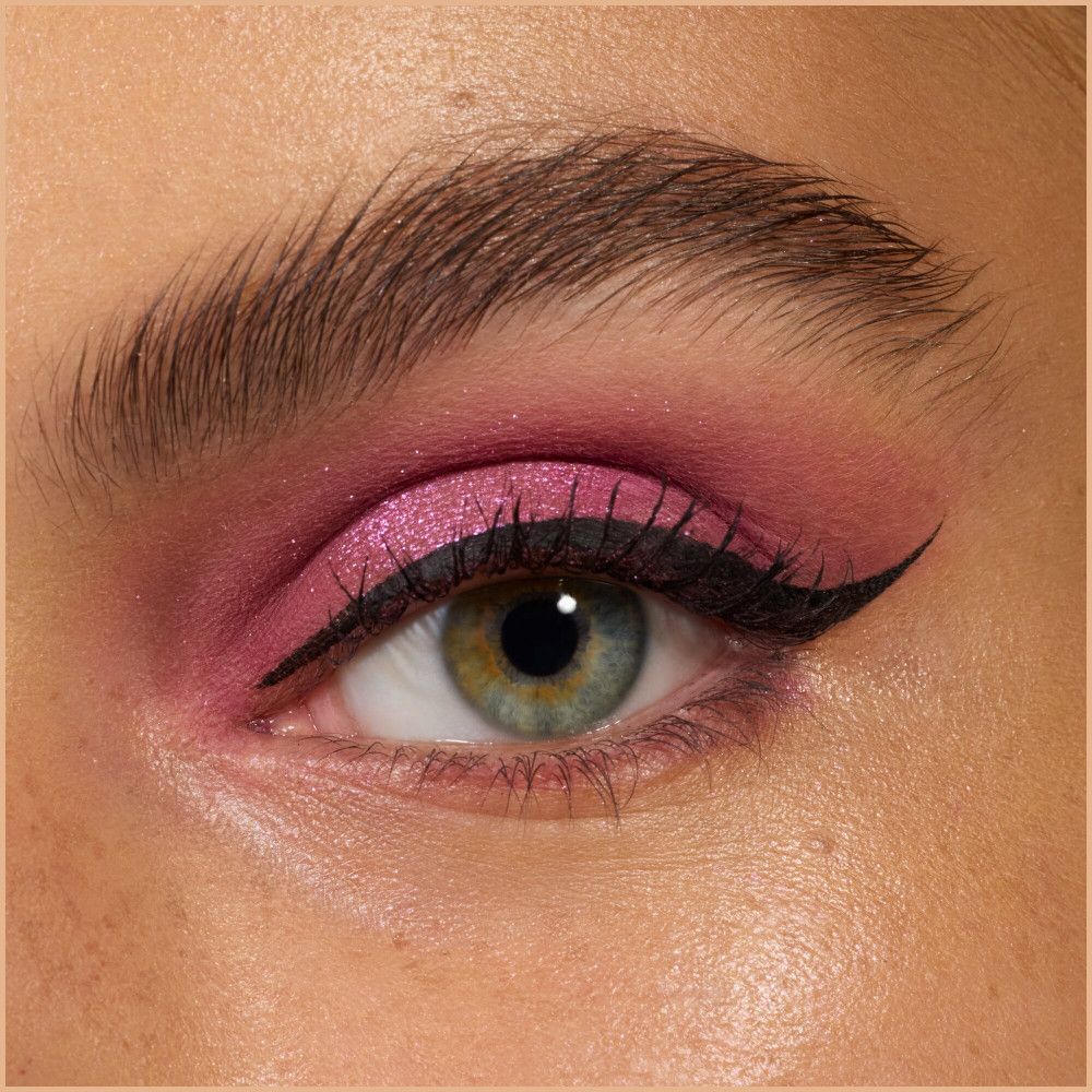Nahaufnahme eines Auges mit pinkfarbenem Lidschatten und schwarzem Eyeliner. Grünes Auge.