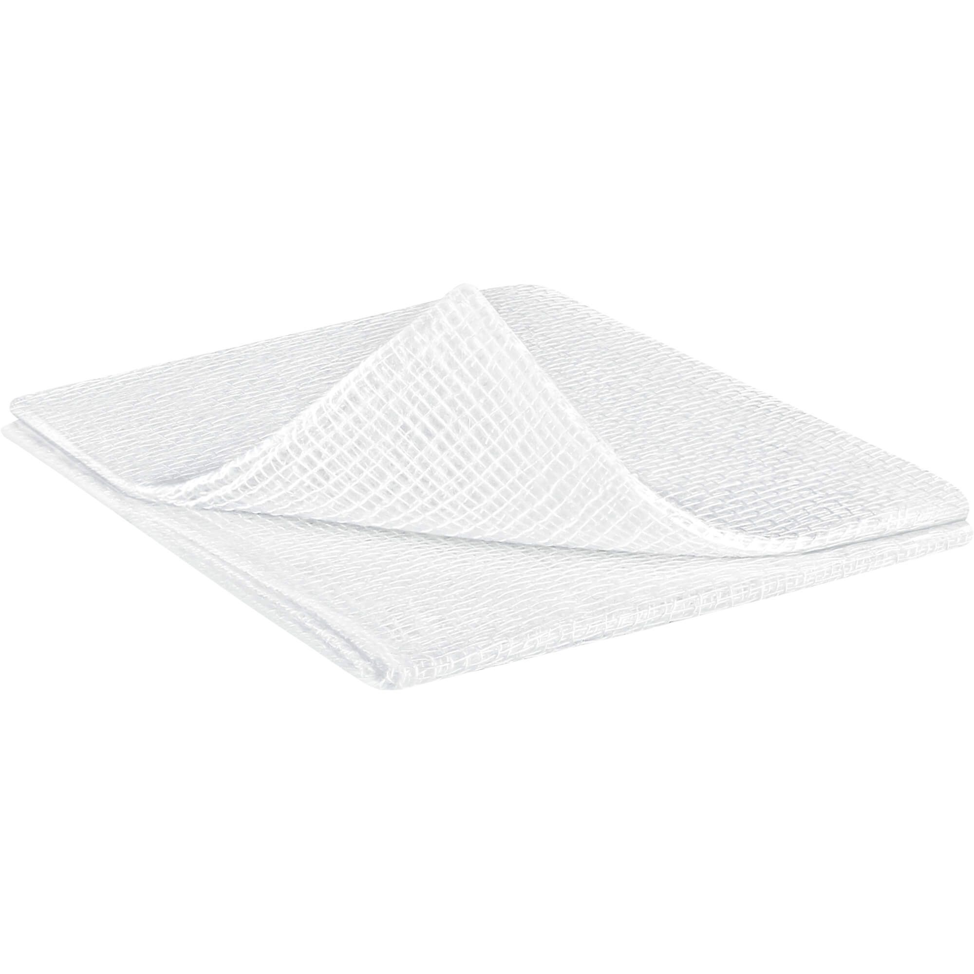 Weiße Mullkompresse, quadratisch, gefaltet. Gewebte Struktur sichtbar. Liegt auf heller Oberfläche.