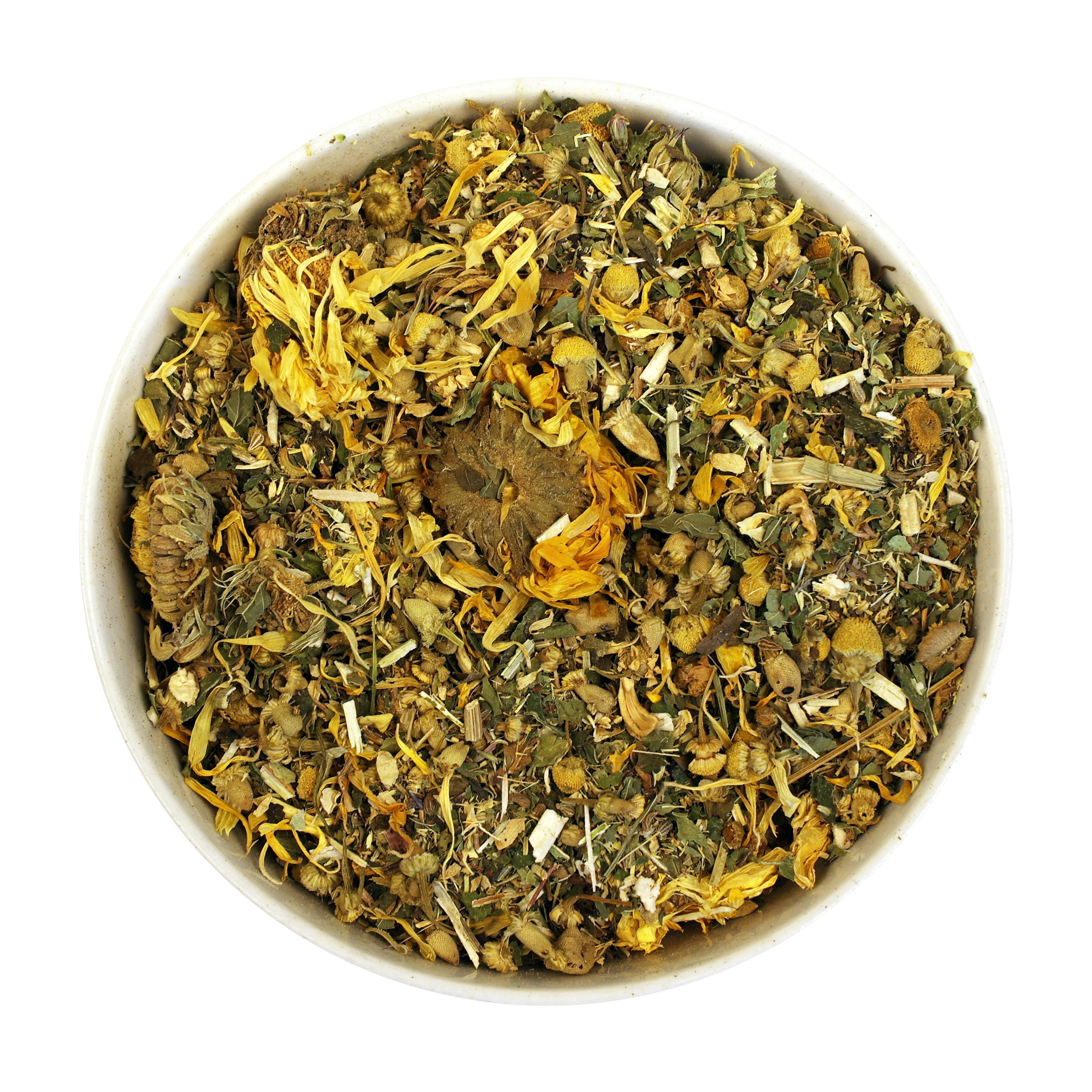 Schüssel mit Kräutermischung. Gelbe Blüten, grüne Blätter und braune Bestandteile. Auf weißem Hintergrund.