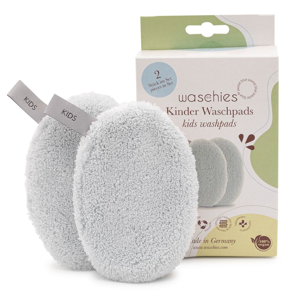 Zwei ovale, hellgraue Waschpads mit Etiketten "KIDS" und Verpackung. Auf der Verpackung steht "Waschies Kinder & Babys".