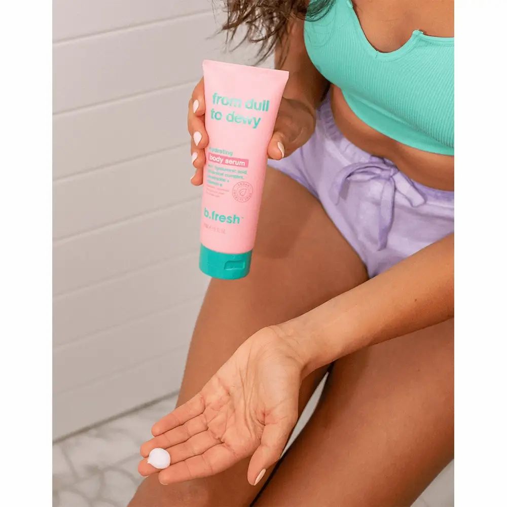 Person hält eine rosa Tube mit türkis Verschluss. Aufschrift: From Dull To Dewy. Produkt wird auf die Hand aufgetragen.