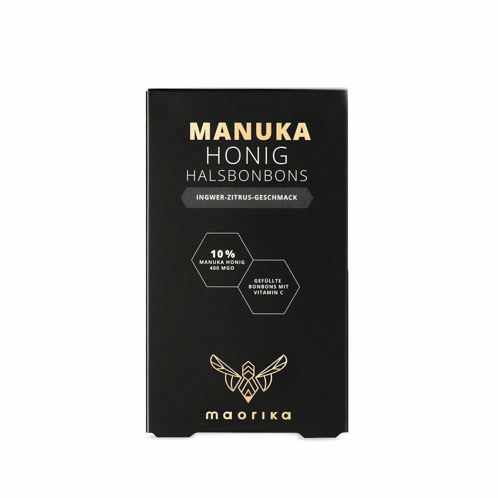 Schwarze Verpackung mit goldener Schrift. "Manuka Honig Halsbonbons" und "Ingwer-Zitrus-Geschmack" sind sichtbar.