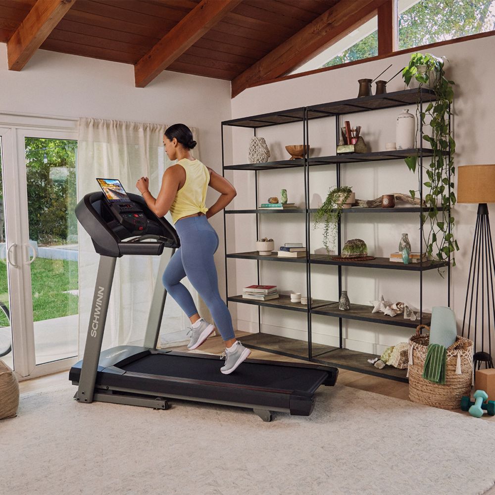 Frau läuft auf einem Laufband. Schwarzes Laufband, grauer Rahmen. Schwinn Fitness SFT 3.5.